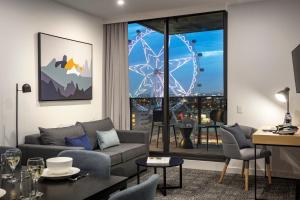 a living room with a couch and a large window at Quest NewQuay in Melbourne
