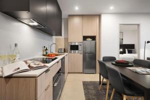 a kitchen with a counter and a dining room at Quest NewQuay in Melbourne