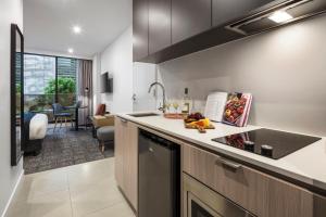 a kitchen with a sink and a counter top at Quest NewQuay in Melbourne