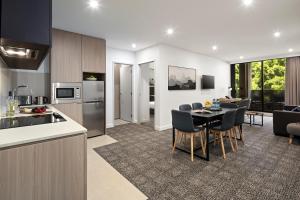 a kitchen and living room with a table and chairs at Quest NewQuay in Melbourne