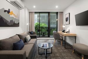 a living room with a couch and a desk at Quest NewQuay in Melbourne