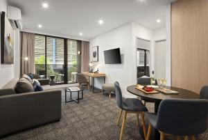 a living room with a couch and a table at Quest NewQuay in Melbourne