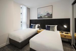 a hotel room with two beds and a window at Quest NewQuay in Melbourne