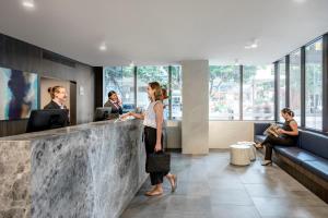 a woman standing at a counter in a lobby at Quest NewQuay in Melbourne