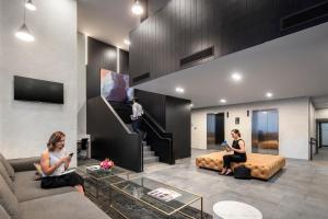 two women sitting in a living room with a couch at Quest NewQuay in Melbourne
