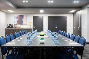 a long table in a room with blue chairs at Quest NewQuay in Melbourne
