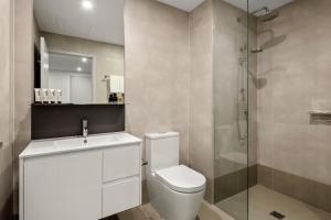 a bathroom with a toilet and a glass shower at Quest NewQuay in Melbourne