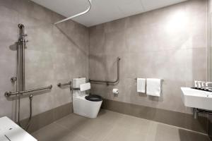 a bathroom with a toilet and a sink at Quest NewQuay in Melbourne