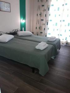 a bedroom with two beds with towels on them at Hermes in Agia Marina Aegina