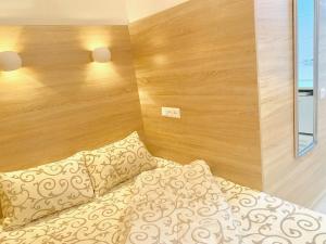 1 dormitorio con 1 cama y pared de madera en Mini- Smart апартаменти в центральній частині Львова, en Leópolis
