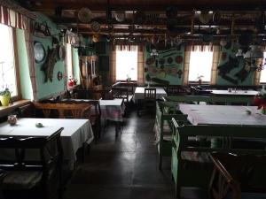 an empty restaurant with tables and chairs and windows at Somogyi Vendégház in Bancu