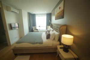 een slaapkamer met een bed, een lamp en een raam bij Marrakesh Residence 325 in Hua Hin