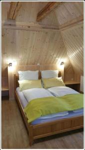 Cama en habitación con techo de madera en Ferienwohnung - Landhotel Waldschlößchen en Sohland