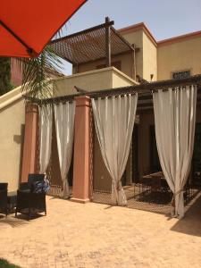 a group of white curtains in front of a building at Villa entière GOLF MARRAKECH in Marrakech