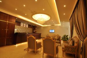 a lobby with a waiting room with chairs and a chandelier at Rozaio Hotel in Jeddah