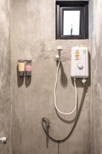 a bathroom with a shower with a soap dispenser at The Cocoon Hostel in Bangkok