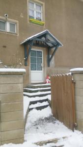 Una puerta de una casa con nieve en las escaleras en Ferienwohnung Charlett, en Dresden