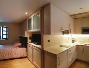 a kitchen with white cabinets and a bed in a room at Villa Cudillero - recep H Isabel in Cudillero