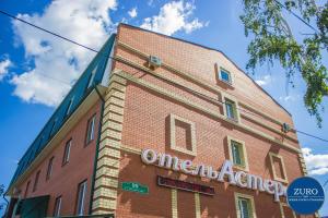 a brick building with a sign on the side of it at Aster Hotel-ZURO in Ulyanovsk