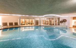 una gran piscina en un edificio en Alpenheim Charming & Spa Hotel, en Ortisei
