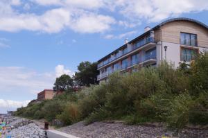 a building on top of a hill next to the ocean at Apartament na Klifie DUNE in Ustronie Morskie