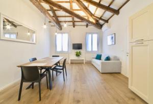 - une salle à manger avec une table, des chaises et un canapé dans l'établissement New apartment in Murano the amazing glass island, à Murano