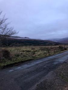 an empty road in the middle of a field at Edindoune in Strathcarron