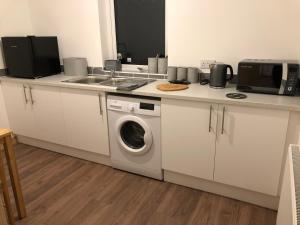 a kitchen with a washing machine and a sink at Edindoune in Strathcarron