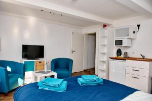 a bedroom with a blue bed and a kitchen at Townhouse Duderstadt in Duderstadt