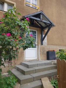 una puerta de entrada de una casa con flores rosas en Ferienwohnung Charlett, en Dresden