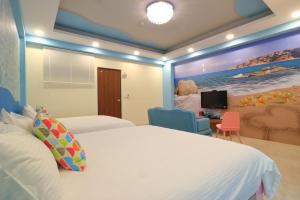a bedroom with a large bed and a tv at Romantic B&B in Hualien City