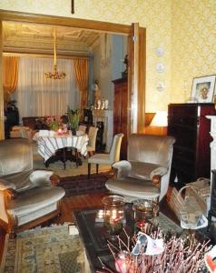 a living room with chairs and a couch and a table at B&B Villa D'Hondt in Blankenberge