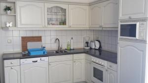 a kitchen with white cabinets and a sink at Ferienwohnung "An der Würschnitz" in Chemnitz +12 photos
