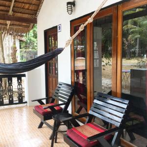 two chairs and a hammock on a porch at Papillon Bungalows in Ko Lanta
