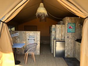uma tenda com uma mesa e uma cadeira em Les Lodges Saint Pierre em Cap d'Agde