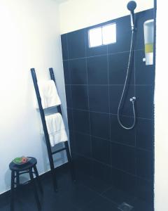 W łazience znajduje się prysznic i niebieska ściana wyłożona kafelkami. w obiekcie Papillon Bungalows w mieście Ko Lanta