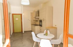 una piccola cucina con tavolo e sedie bianchi di Appartamento sulla spiaggia a Gallipoli