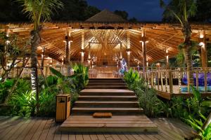 a wooden walkway leading into a resort at night at Phi Phi CoCo Beach Resort in Phi Phi Islands