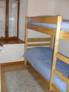 a bedroom with two bunk beds and a window at Location appartement 6 personnes in Génos