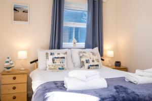オールドバラにある17 Britten Close - Aldeburgh Coastal Cottagesのベッドルーム1室(白いベッド1台、枕付)、窓が備わります。