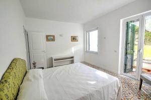 - une chambre blanche avec un lit et une fenêtre dans l'établissement CASA LONE, à Amalfi