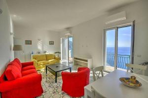 - un salon avec des chaises rouges, un canapé et une table dans l'établissement CASA LONE, à Amalfi