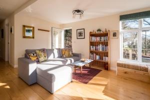 a living room with a couch and a book shelf at The Retreat in Leiston