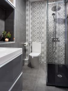 a bathroom with a toilet and a glass shower at Entrevias Lodging - Apartamento con Garaje y WIFI in León