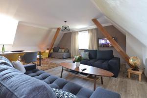 un soggiorno con un divano blu e un tavolo di Gîte Aux Deux Clochers a Zimmersheim