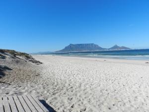 a white sandy beach with mountains in the background at Sunset at Diluta in Cape Town