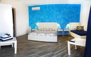 a bedroom with a bed and a blue wall at Borgo Marino Suite B&B in Cefalù
