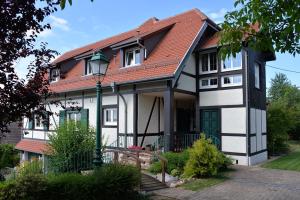 una casa bianca e nera con tetto rosso di Gîte Aux Deux Clochers a Zimmersheim