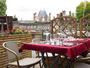 una mesa con copas de vino en el patio en Le Richelieu Bacchus, en Fontainebleau