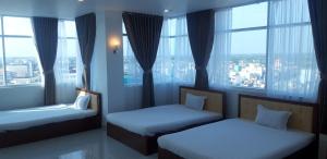 Habitación de hotel con 2 camas y ventanas grandes. en Sao Kim en Cà Mau